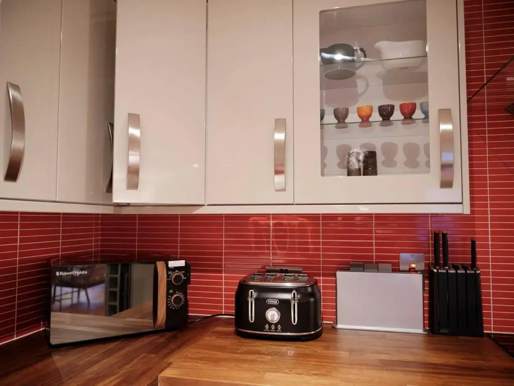 a kitchen with a toaster and a microwave on a counter at The Steadings, Aviemore Luxury 5 star rated 3 Bed with home cinema garden and parking in Aviemore