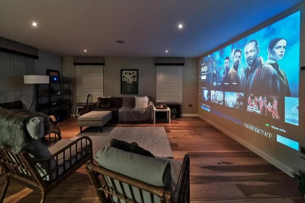 a large screen in a living room with a couch at The Steadings, Aviemore Luxury 5 star rated 3 Bed with home cinema garden and parking in Aviemore