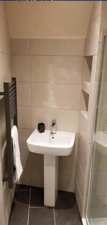 a bathroom with a white sink and a shower at Ness City Apartment in Inverness