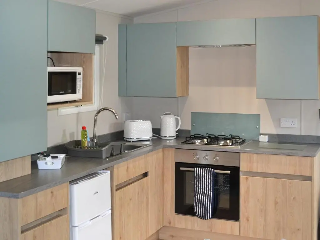a kitchen with blue cabinets and a stove top oven at The Finch in Dyke