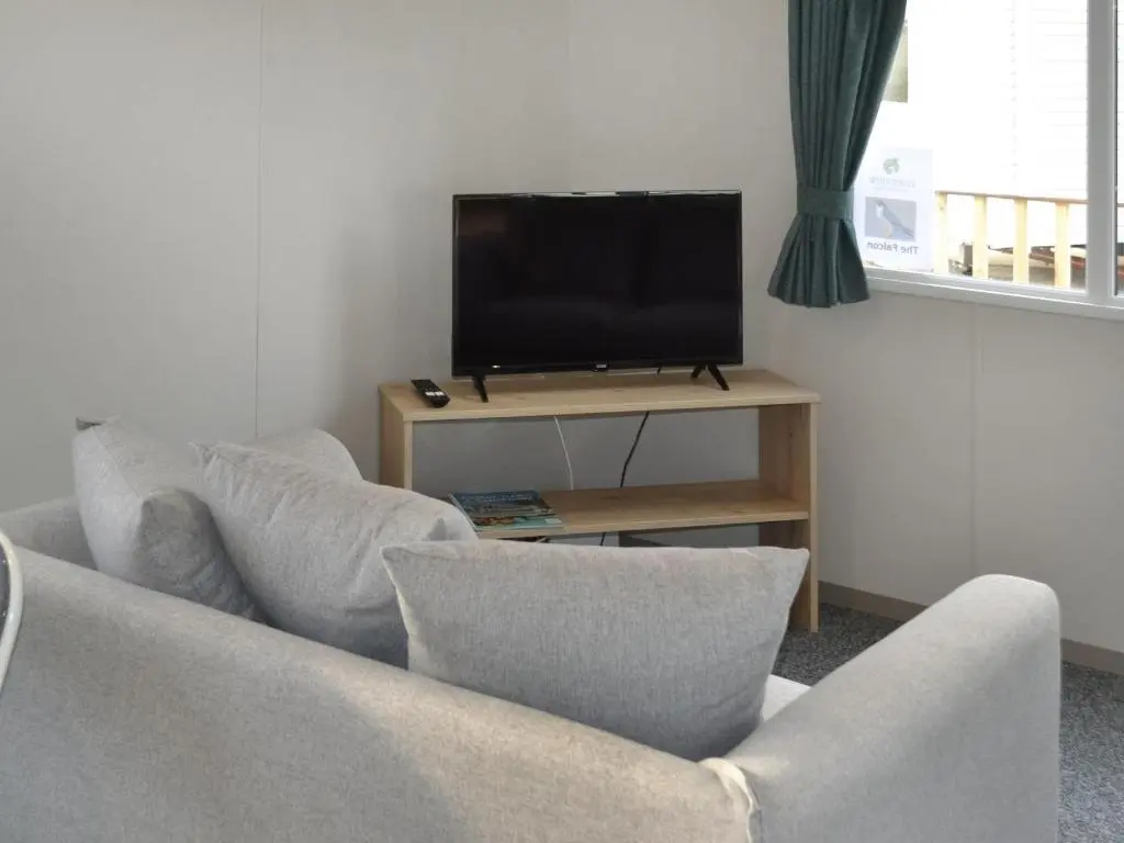 a living room with two chairs and a flat screen tv at The Falcon - Uk45538 in Dyke