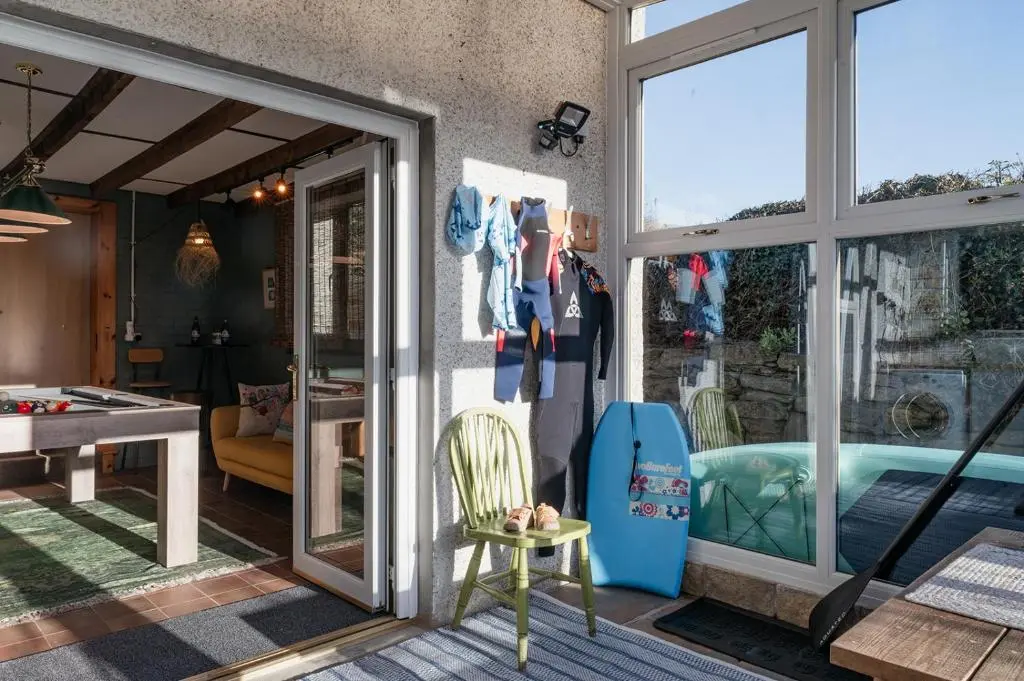 a room with sliding glass doors and a pool at Ina's Cottage - Seasgair Lodges in Portmahomack