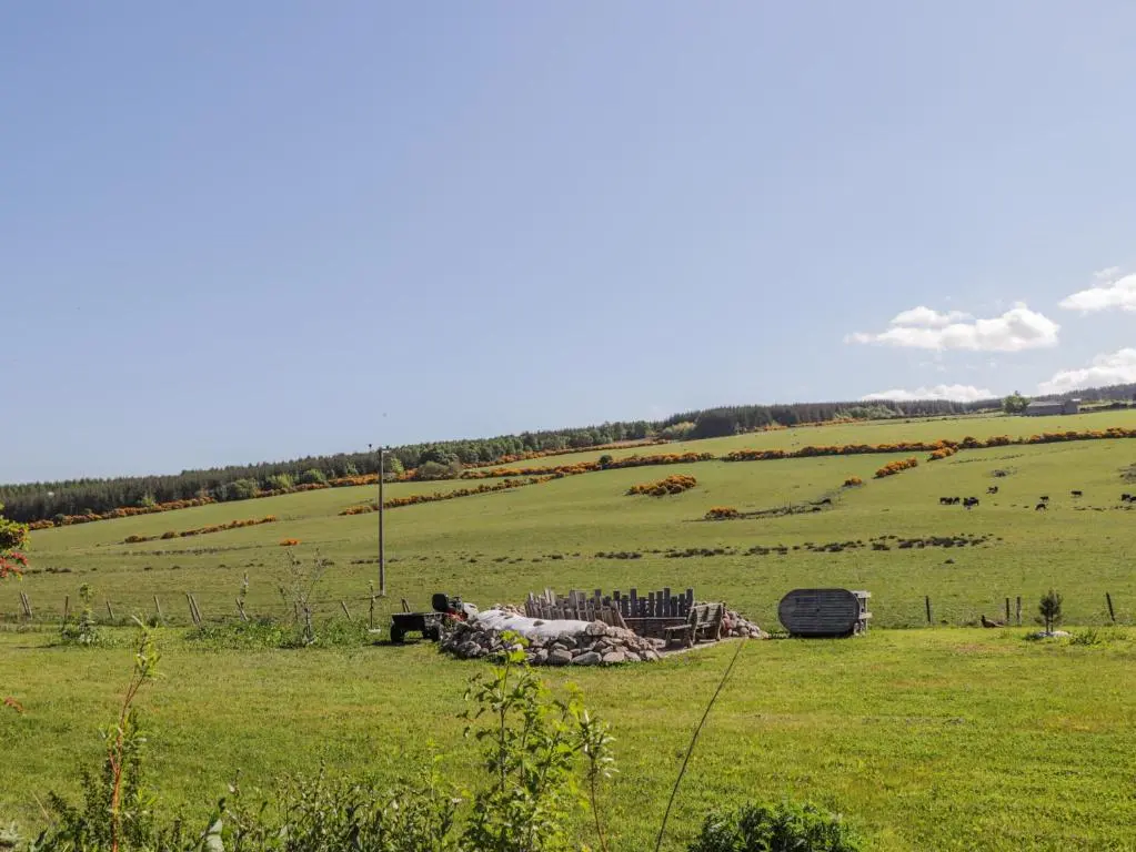 a green field with a barn in the middle of it at Easter Blervie in Forres