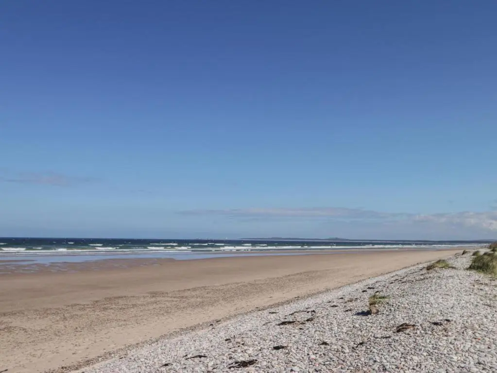 a sandy beach with the ocean in the background at Easter Blervie in Forres
