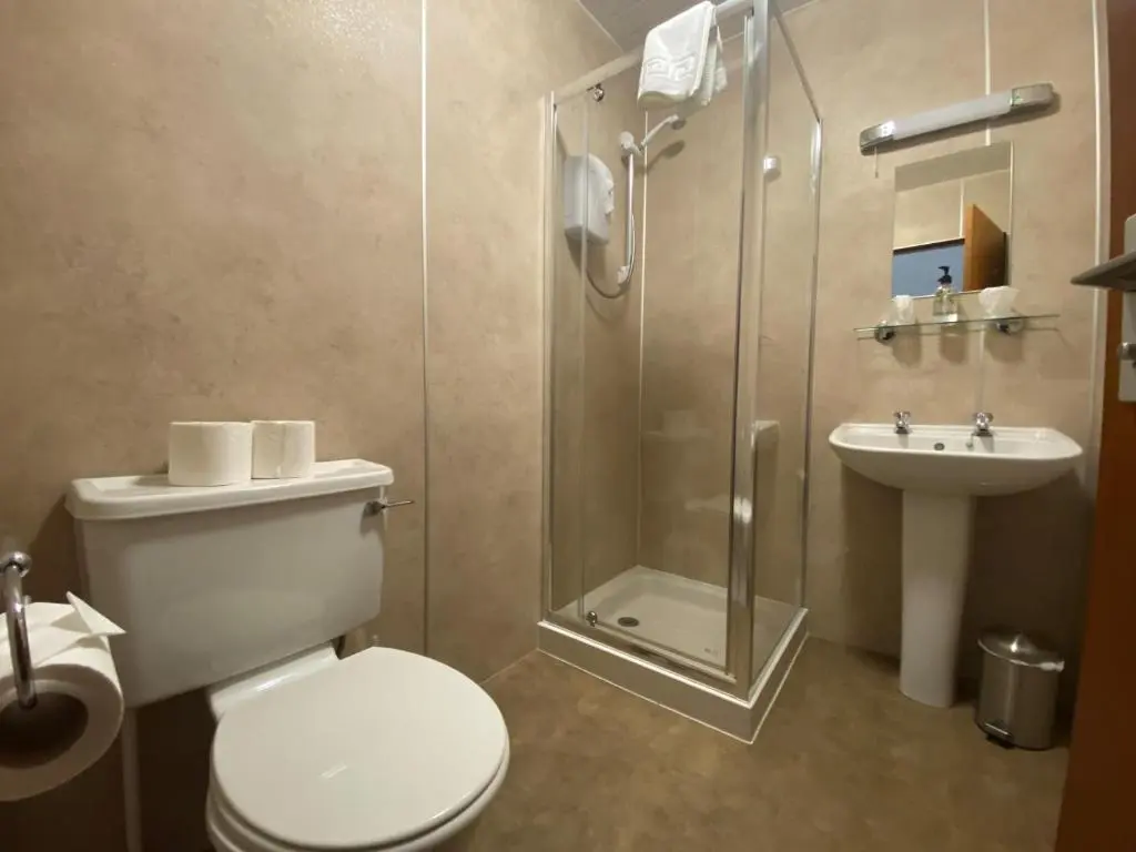 a bathroom with a shower and a toilet and a sink at Smithton Hotel in Inverness