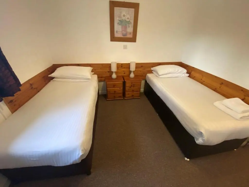 two twin beds in a room with at Smithton Hotel in Inverness