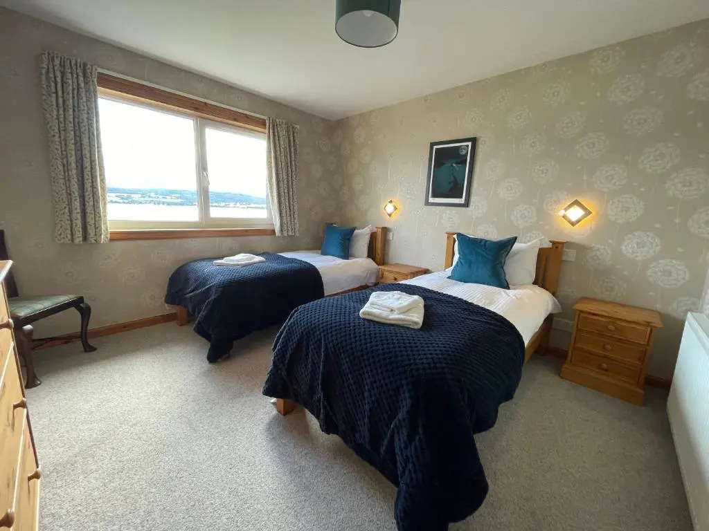 a hotel room with two beds and a window at Peaceful Sea View Home only 5 miles from Inverness in North Kessock