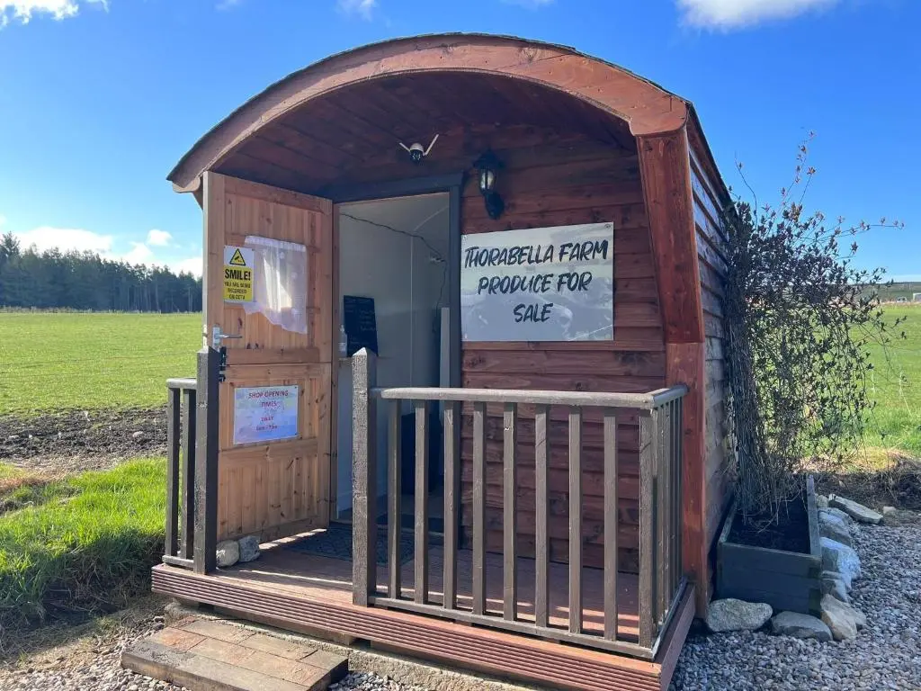 a wooden out house with a sign on it at Willow Straw Bale Cabin
