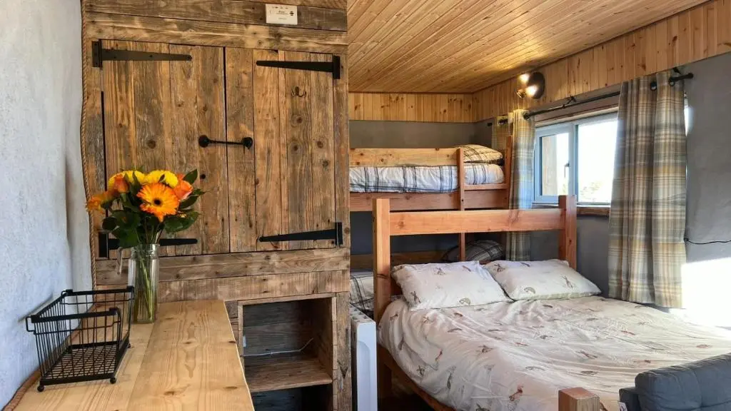 a bedroom with a bed and two bunk beds at Primrose Straw Bale Cabin
