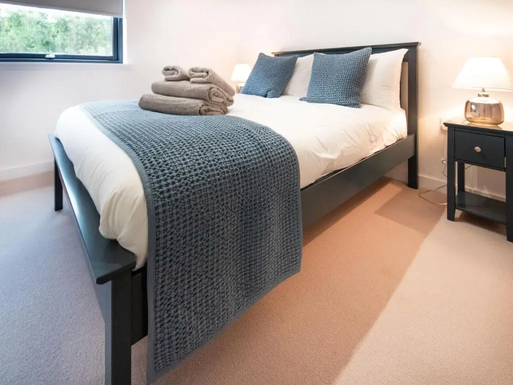 a bedroom with a bed with a blue blanket on it at Caledonia View in Aviemore