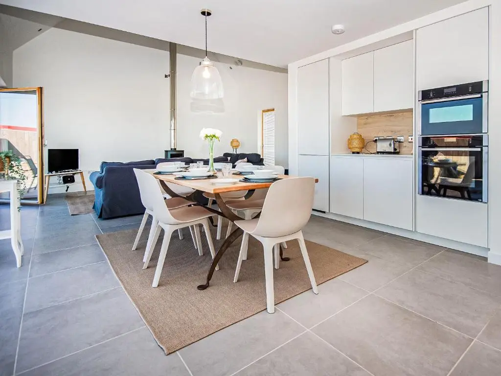 a kitchen and dining room with a table and chairs at Y Bwthyn in Culbokie