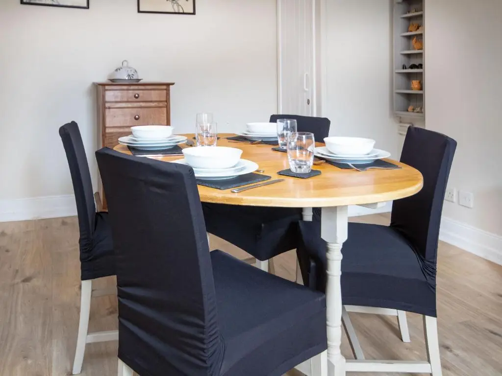 a dining room table with black chairs and a wooden table at Solus Na Madainn in Tain
