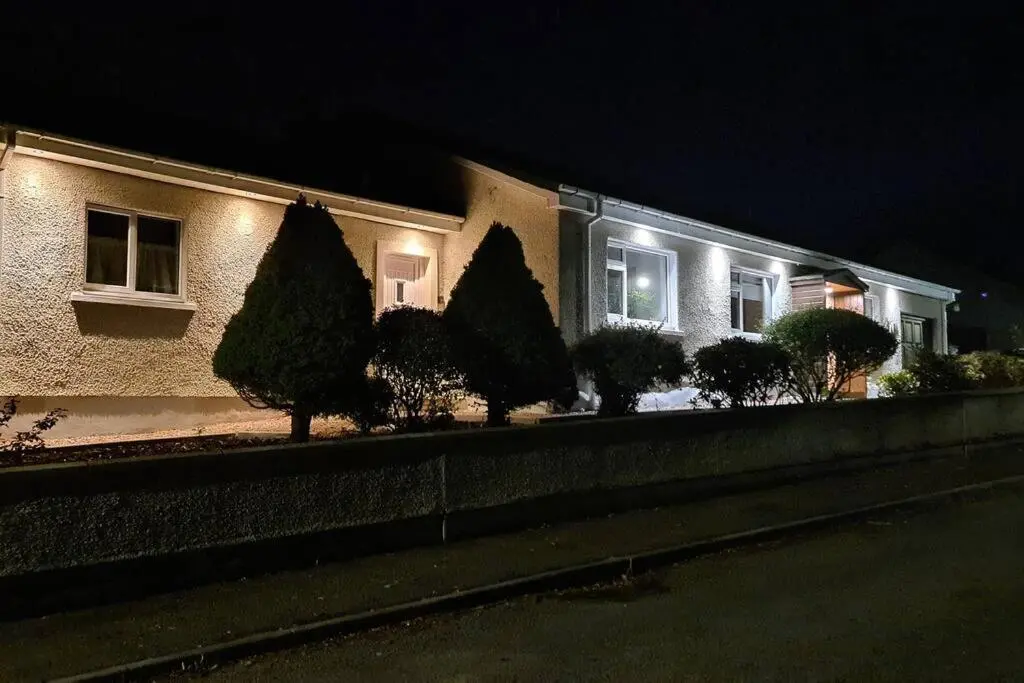 a house with trees in front of it at night at Northlea-Scottish style cottage in Inverness