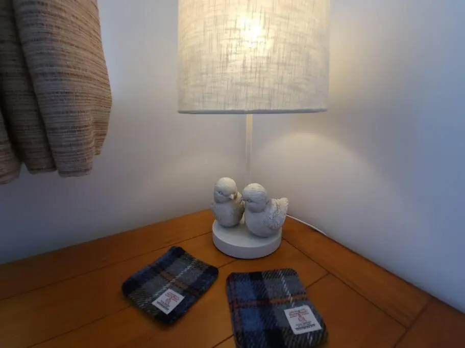 two birds figurines sitting on a table next to a lamp at Northlea-Scottish style cottage in Inverness