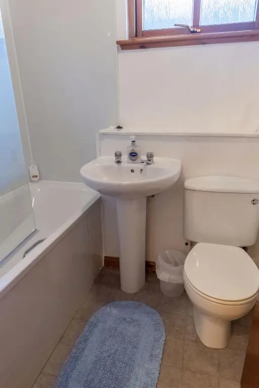a white bathroom with a toilet and a sink at Apartment Towerhill Heights by Interhome in Inverness
