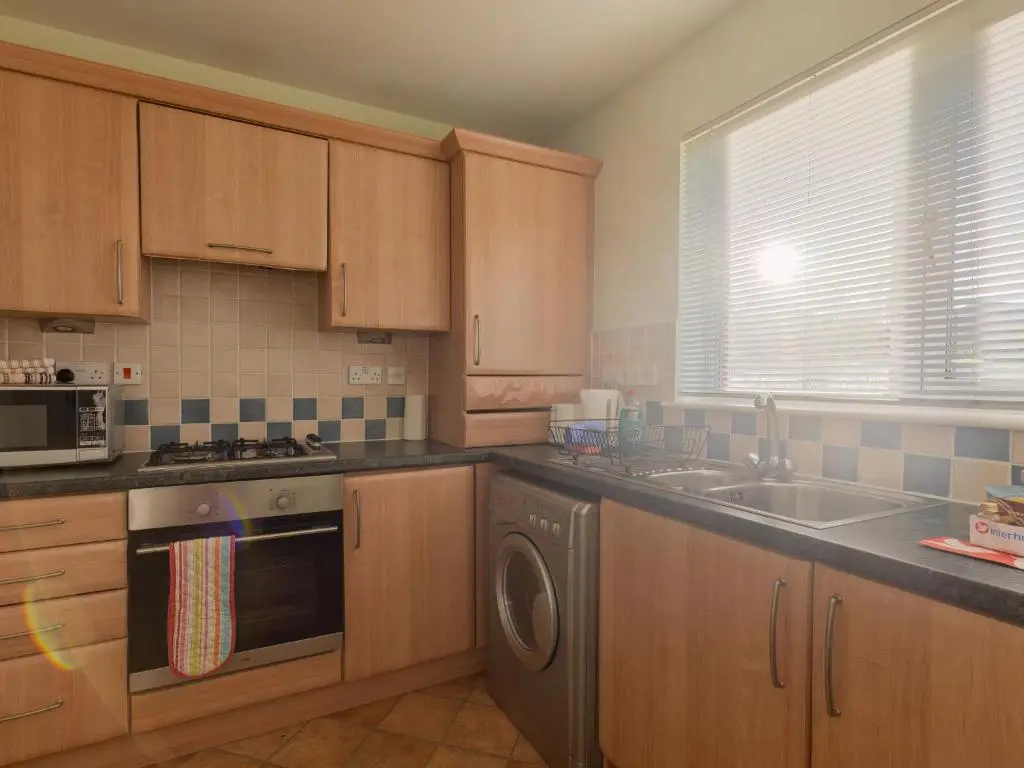 a kitchen with wooden cabinets and a sink and a dishwasher at Apartment Ash House by Interhome in Inverness