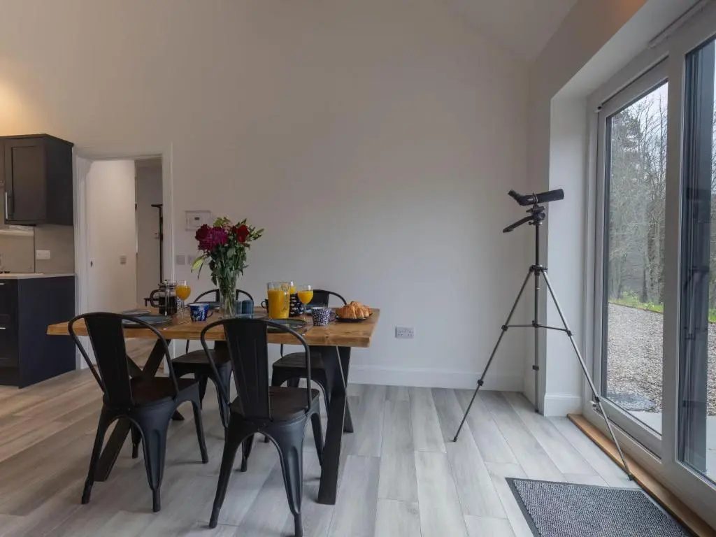 a dining room with a table and a camera on a tripod at Holiday Home Loch View by Interhome in Balnain