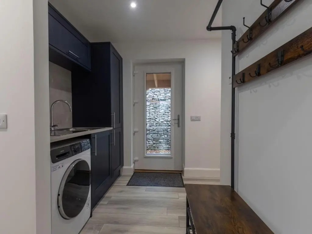 a kitchen with a washer and dryer next to a door at Holiday Home Loch View by Interhome in Balnain