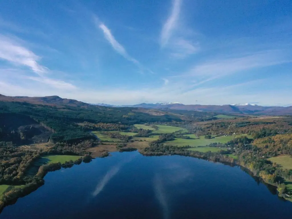 an aerial view of a lake with trees and water at Holiday Home Loch View by Interhome in Balnain