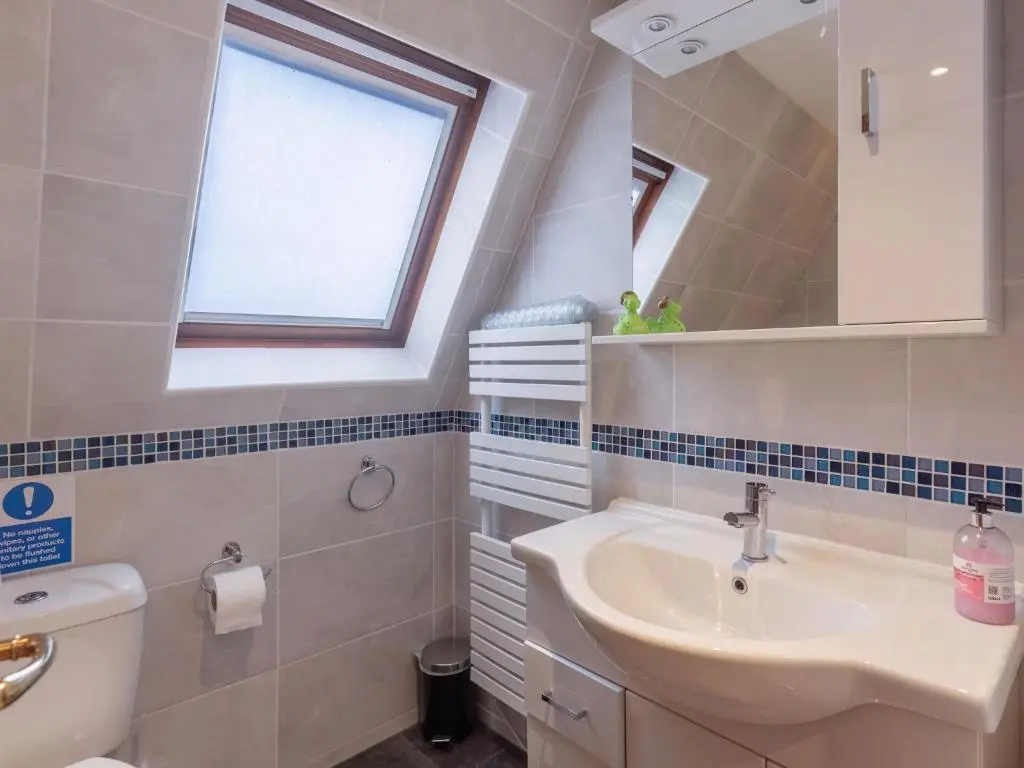 a bathroom with a sink and a toilet and a window at Chalet Lothlorien Lodge 4 by Interhome in Spean Bridge