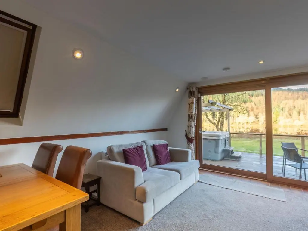 a living room with a couch and a table at Chalet Lothlorien Lodge 4 by Interhome in Spean Bridge