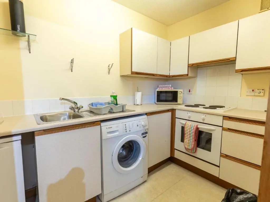 a kitchen with a washing machine and a sink at Apartment Miller Heights by Interhome in Inverness