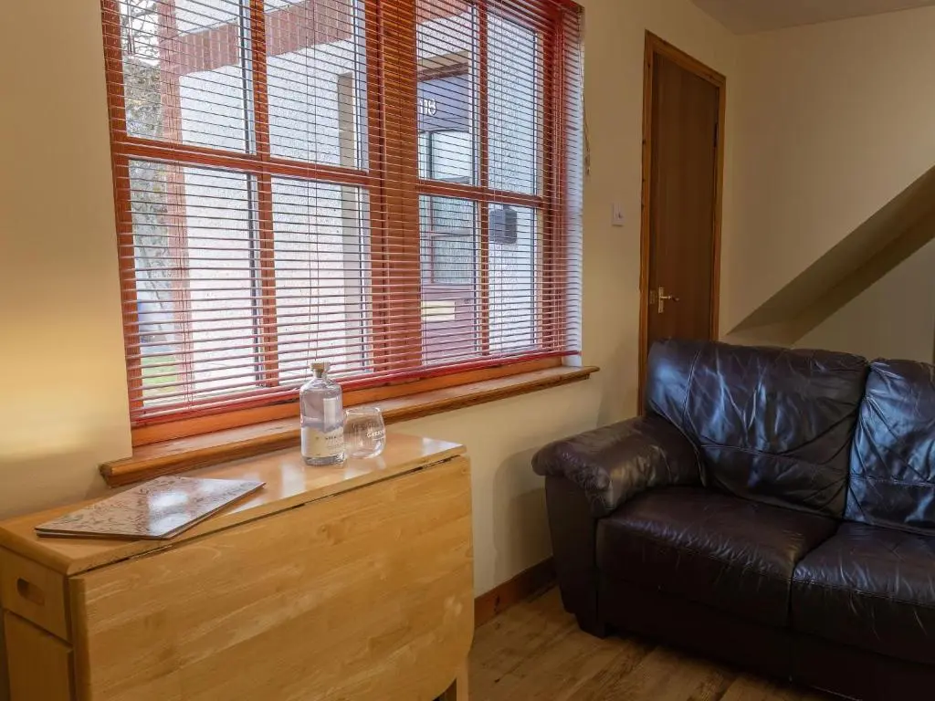 a living room with a leather couch and a window at Apartment Miller Heights by Interhome in Inverness