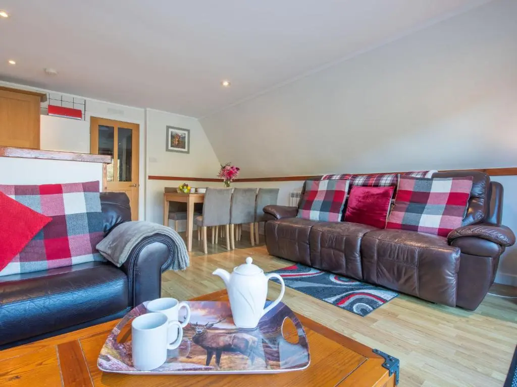 a living room with two couches and a table at Chalet Woodhaven by Interhome in Spean Bridge