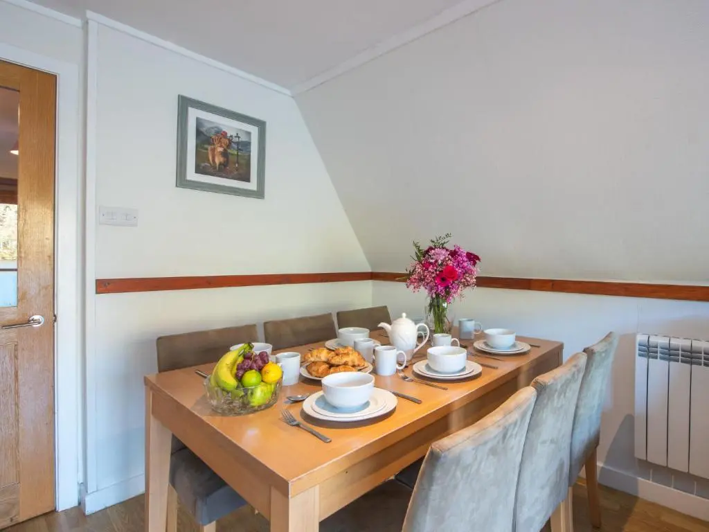 a wooden table with a bowl of fruit on it at Chalet Woodhaven by Interhome in Spean Bridge
