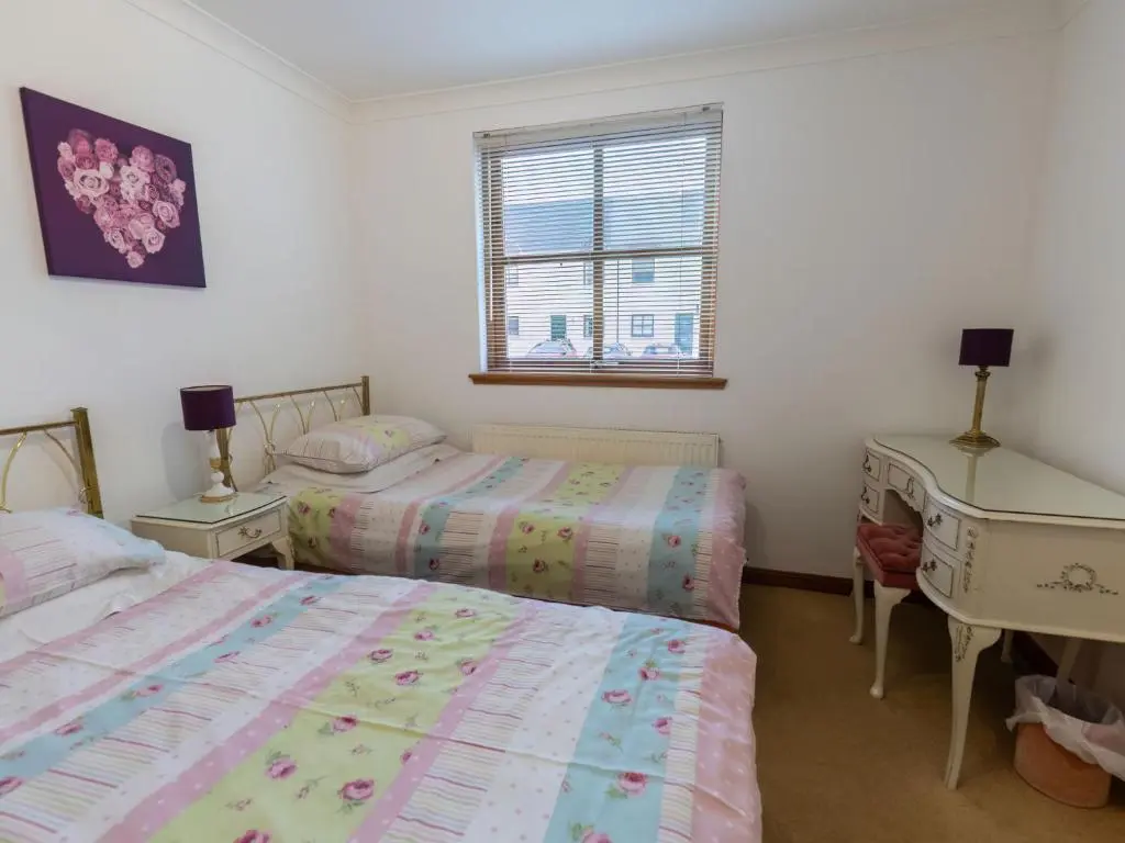 two beds in a room with a desk and a bed at Apartment Elm Grove by Interhome in Inverness