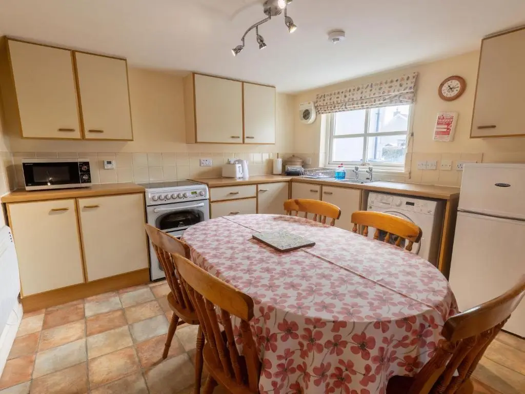 a kitchen with a table with a table cloth on it at Holiday Home Old Lodge by Interhome in Inverness