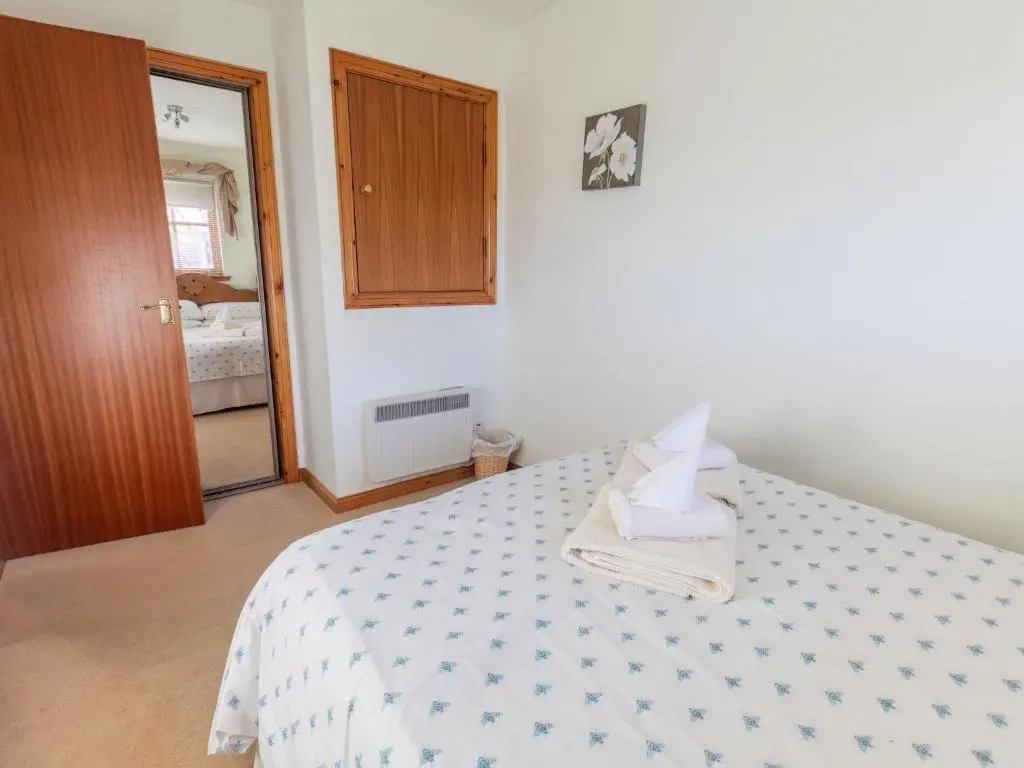 a bedroom with a bed with a blue and white comforter at Apartment Millar House by Interhome in Inverness
