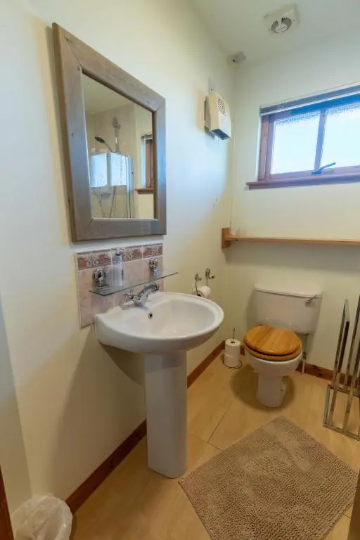 a bathroom with a sink and a toilet and a mirror at Apartment Millar House by Interhome in Inverness