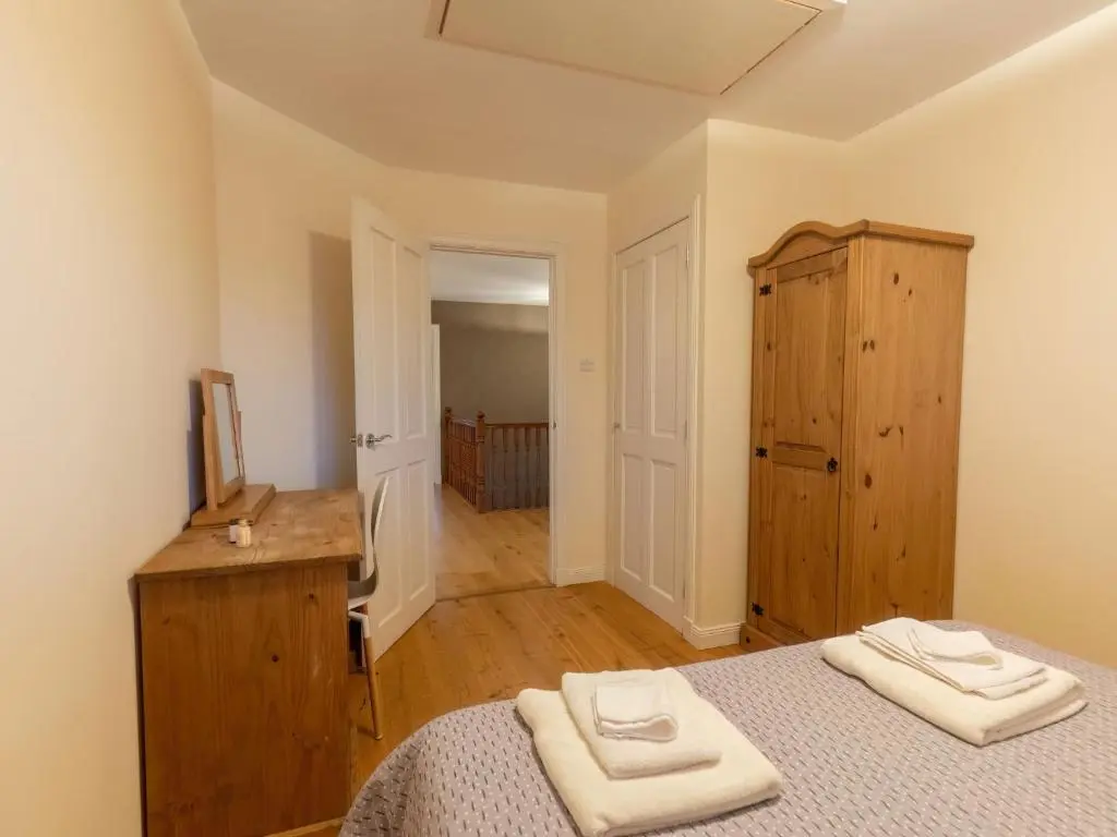 a bedroom with a bed and a wooden cabinet at Villa Evergreen House by Interhome in Inverness