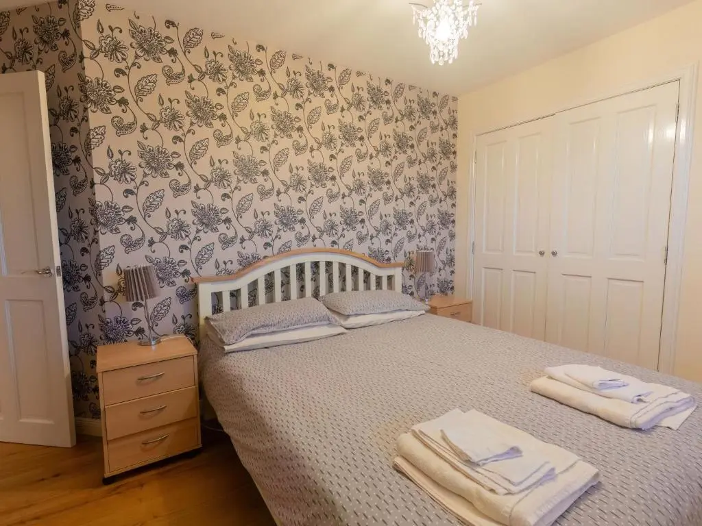 a bedroom with a bed with two towels on it at Villa Evergreen House by Interhome in Inverness