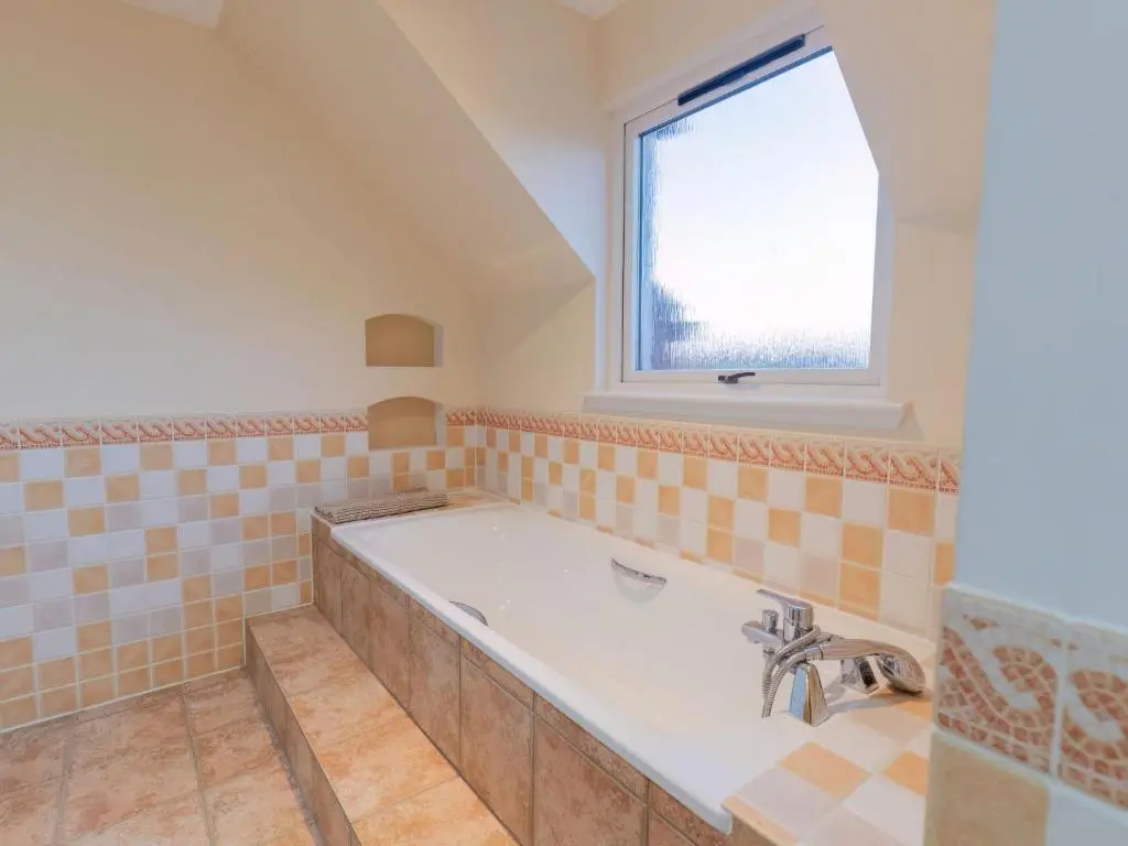 a large bathroom with a tub and a window at Villa Evergreen House by Interhome in Inverness