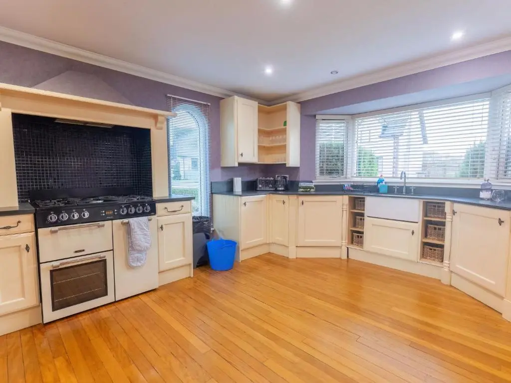 a large kitchen with white appliances and wooden floors at Villa Evergreen House by Interhome in Inverness
