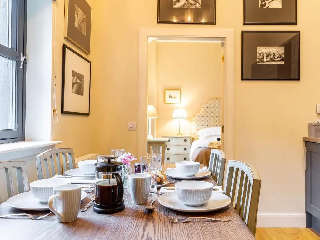 a dining room with a table with plates and chairs at 1 Bed in Forres 78430 in Forres