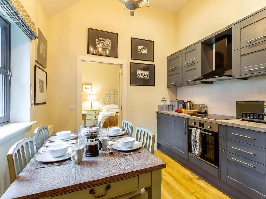 a kitchen with a table with chairs and a dining room at 1 Bed in Forres 78430 in Forres