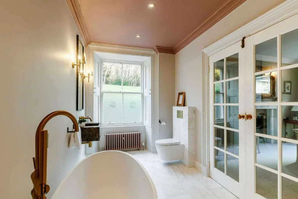 a bathroom with a tub and a toilet and a window at Manar House Ground Floor Luxury Apartment in Inverurie