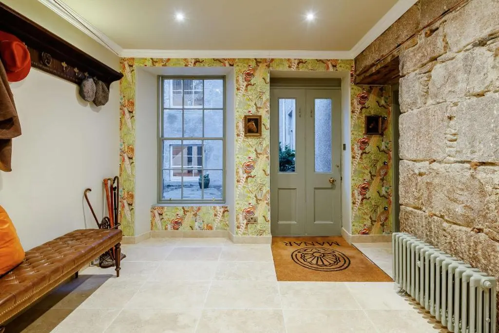 a hallway with a door and a stone wall at Manar House Ground Floor Luxury Apartment in Inverurie
