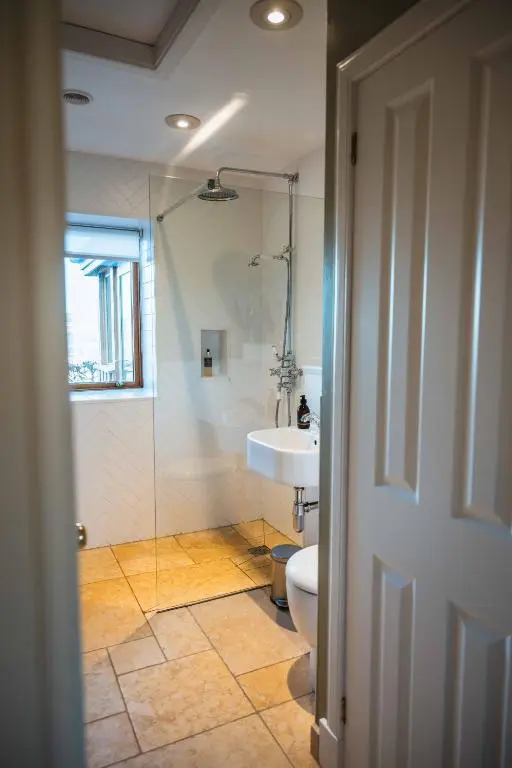 a bathroom with a toilet and a sink and a shower at Kinkell Cottage in Dingwall
