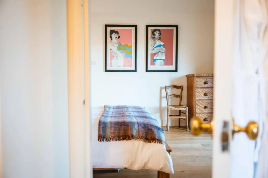 a bedroom with three framed pictures on the wall at Kinkell Cottage in Dingwall