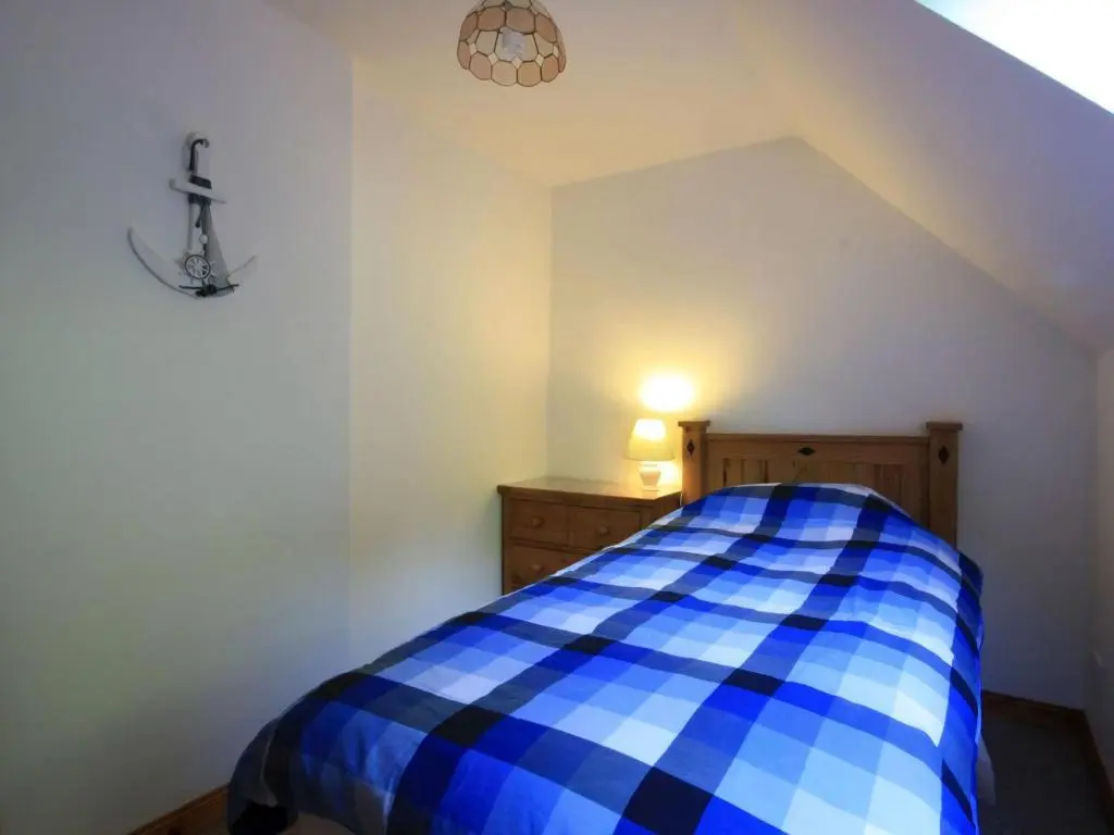 a bedroom with a blue and white checkered bed at The Old Chandlery in Avoch