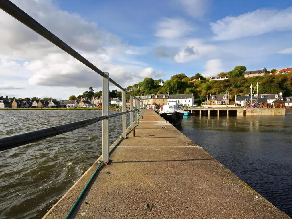 a dock with a boat in the water at The Old Chandlery in Avoch