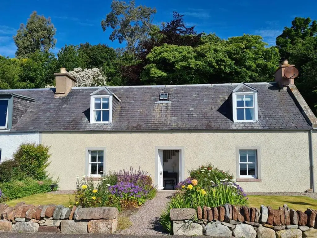 a large white house with a stone wall at Braefoot in Fortrose