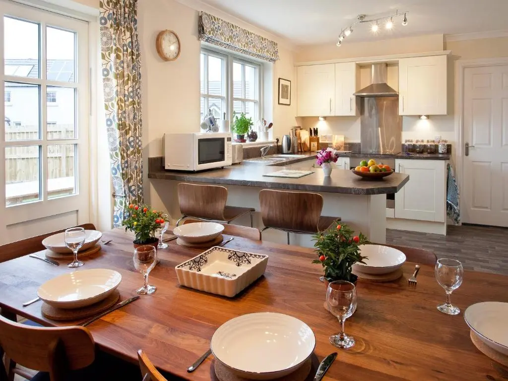 a kitchen and dining room with a wooden table at Mackay Road - Uk7451 in Dornoch