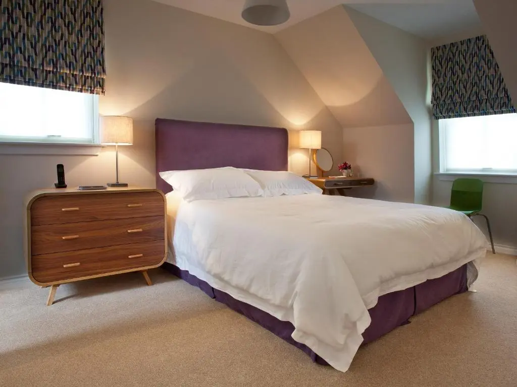 a bedroom with a large bed and two windows at Mackay Road - Uk7451 in Dornoch