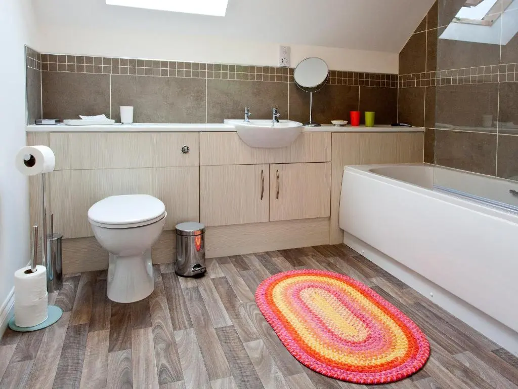 a bathroom with a toilet and a sink and a rug at Mackay Road - Uk7451 in Dornoch