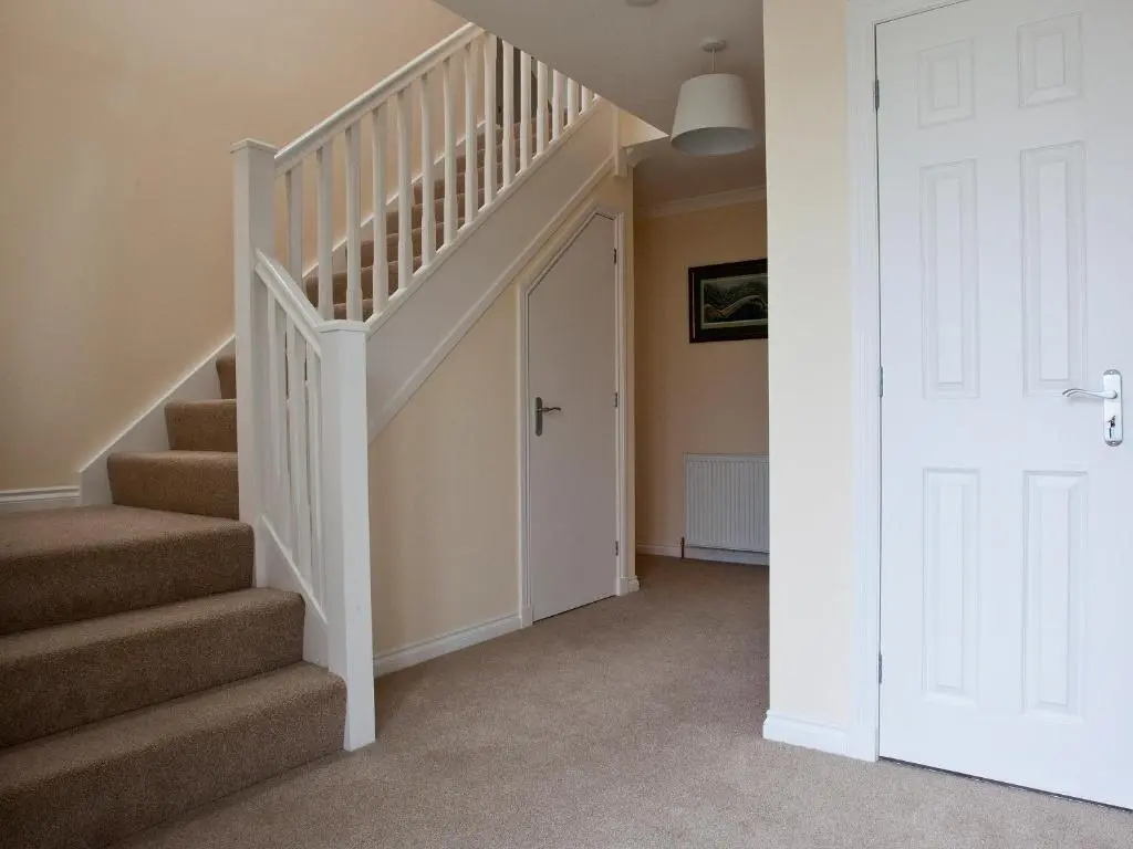 a staircase in a home with a white door at Mackay Road - Uk7451 in Dornoch